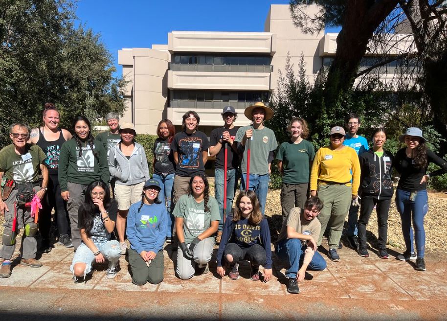 Group of students posing for group picture at planting event. 