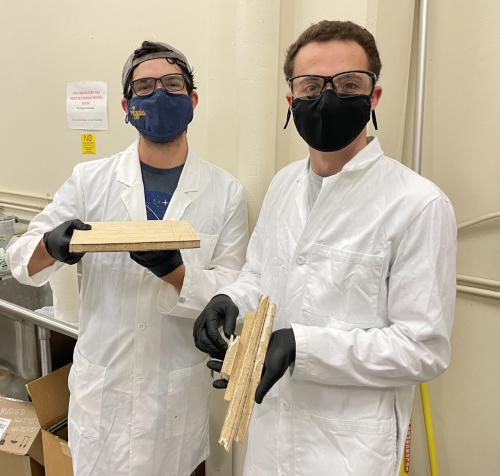 Undergraduate student researcher Santiago Mejia (left) and Alex Weinstein (right) with samples of mycelium/biomass and plywood. Photo courtesy of Valeria La Saponara.